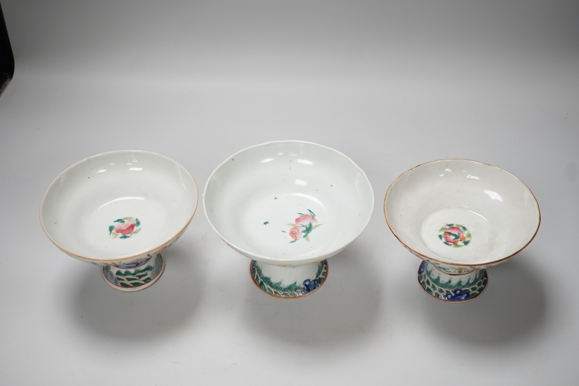 Three 19th century Chinese famille rose pedestal stem bowls, each painted with flowers and foliage, 9.5cm tall